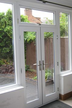 an empty room with double doors and windows