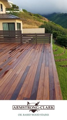 a wooden deck in front of a house with mountains in the backgroung