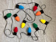 several christmas lights are laid out on a gray t - shirt with black stringing