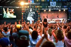 a crowd of people at a concert with their hands in the air