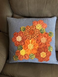 an orange and yellow flower on a blue pillow