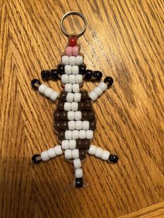 a keychain made out of candy and plastic beads on a wooden table with a red nose