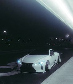 a white sports car is parked on the street