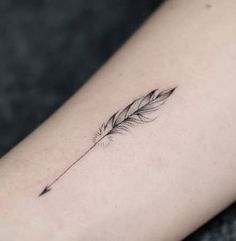 a small feather tattoo on the arm