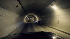 people are walking through a tunnel in the dark