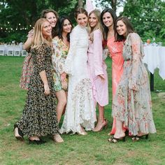 a group of women standing next to each other on top of a lush green field