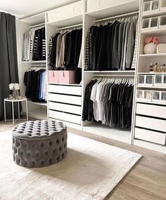 a walk - in closet with white shelving and lots of clothes on the shelves