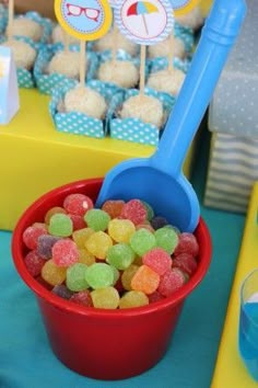 a red bowl filled with gummy bears on top of a blue and yellow table