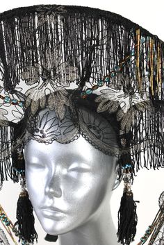 A headdress for conjuring the mystical, the magical, the feminine. Materials: Vintage lace (therefore has some tears), glass beads, silk dupioni, fringe, sculpting wire, vintage beads, vintage afghani kuchi tassels Tie straps on back of head One-of-a-kind couture wearable art Handcrafted All headgear sales are final. Due to the unique nature of these works of art, coupon codes will not be accepted. MeasurementsApprox 6" headband width, 14" total width, 11" height, 9" lower lace, tieable straps Adjustable Bohemian Tall Crown Headpiece, Bohemian Adjustable Tall Crown Headpiece, Handmade Elegant Festival Headpiece, Elegant Handmade Festival Headpiece, Bohemian Headpiece With Tall Crown For Costume, Bohemian Costume Hat With Tall Crown, Bohemian Tall Crown Headpiece For Costume, Bohemian Tall Crown Costume Hat For Parties, Bohemian Costume Hat With Tall Crown For Parties