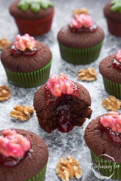 chocolate cupcakes with raspberry filling and walnuts on the side, ready to be eaten