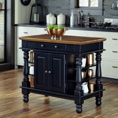 a kitchen island with two cups on it in the middle of a wooden flooring area