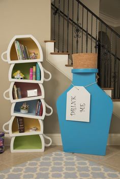 a blue vase sitting next to a white book shelf filled with books and other items