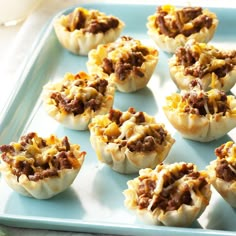 small appetizers with meat and cheese are on a blue tray