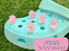 a pair of pink piggie crocs sitting on top of green grass