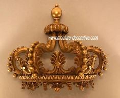 an ornate gold crown on display against a wall