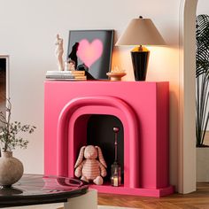 a living room with a pink fireplace and pictures on the wall, vases and lamp