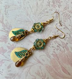 The flowers are sea green Czech glass beads with a gold wash. I layered solid brass teardrops and green patina leaves and hand wrapped, speckled Czech glass teardrops to make interesting dangles to hang from the flowers. I also added small gold accent beads to the flowers to highlight the gold wash and tie in the gold brass teardrops. The hooks are 18k gold plated. Lever back hooks are available upon request.  All of my earrings come on a hand stamped earring card and are lovingly wrapped in col Feather Earrings Diy, Czech Beads Jewelry, Gold Teardrop Earrings, Czech Glass Jewelry, Stamped Earrings, Diy Jewelry Earrings, Green Patina, Earring Card, Long Dangle Earrings