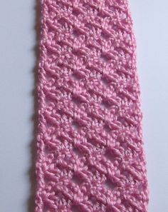 a pink crocheted tie laying on top of a white table