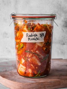 a glass jar filled with food sitting on top of a wooden cutting board