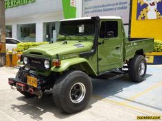 a green jeep parked in front of a building