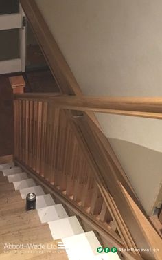 stairs leading up to the second floor in a house with wood handrails and white painted walls