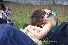 two women sitting in the grass hugging each other