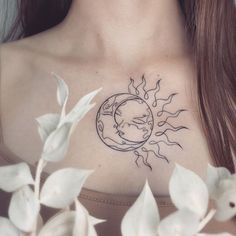 a woman's chest with a sun and moon tattoo on her left side, surrounded by leaves