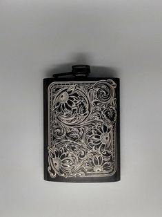 a black flask with an intricate design on it