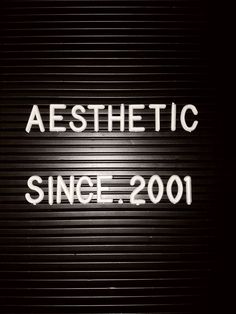 a sign that says aesthetic since 2011 written on the side of a garage door in black and white