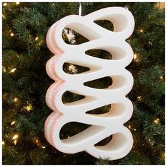 a white ornament hanging from a christmas tree