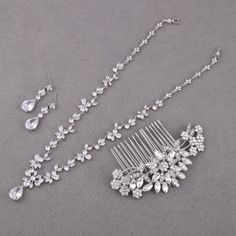 This bridal jewelry set includes a stunning silver necklace, earrings, bracelet, and hair comb, making it a perfect choice for brides and mothers of the bride. Crafted with durable materials, this crystal wedding jewelry is designed to last, and all pieces are nickel- and lead-free for added comfort. Choose your preferred set from the options available.  ✨ Details: CZ NECKLACE: Necklace Length: approx 16 1/2 inches. Materials: cubic zirconia stones & copper, sparkle under lights. CZ EARRINGS: Earring Length about: 1 3/8" (3.5cm) Bottom Teardrop Size: 1/2"H x 3/8"W (1.5cm x 1cm) HAIR COMB: Size: approx width 4 inches (W) by 1 1/2 inches (H).  Materials: clear rhinestones, crystal, ivory pearls,  metal The crystal & pearl hair comb, easy to go with bridal hair styles. CZ BRACELET: Length x W Silver Crystal Jewelry For Marriage, Hand-set Silver Bridal Earrings For Marriage, Silver Hand-set Bridal Earrings For Marriage, Silver Bridal Earrings For Marriage, Hand Set Silver Bridal Earrings, Silver Hand Set Bridal Earrings For Marriage, Silver Cubic Zirconia Bridal Necklace For Marriage, Silver Bridal Accessories With Matching Earrings For Wedding, Silver Bridal Sets With Matching Earrings For Wedding