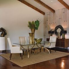 a glass table with white chairs in a room