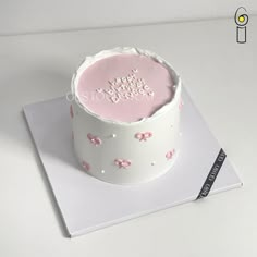 a white cake with pink frosting on top