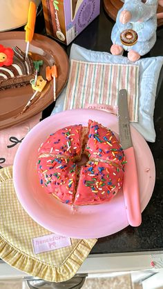 a pink plate topped with a cake covered in sprinkles