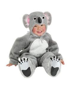 a baby in a koala costume sitting on the ground with one foot up and smiling at the camera