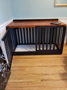 a wooden bench sitting on top of a hard wood floor next to a framed picture