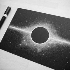 a black and white photo with a pen next to it on top of a table