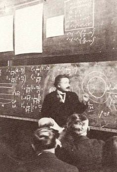 an old black and white photo of men in front of a chalkboard