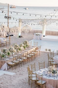 an outdoor wedding setup on the beach with tables and chairs set up in front of it