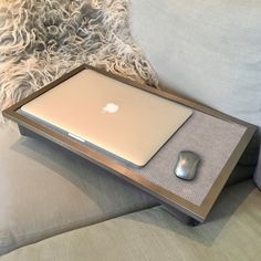 an apple laptop sitting on top of a wooden tray with a mouse pad underneath it