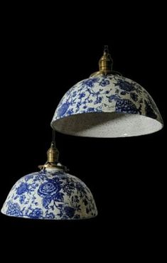 two blue and white hanging lights against a black background