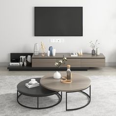 a living room with two coffee tables and a flat screen tv mounted on the wall