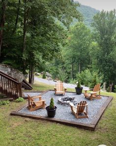 an outdoor fire pit surrounded by lawn chairs and trees in the background with steps leading up to it