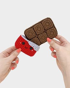 two hands holding up a crocheted cell phone case with a sandwich on it