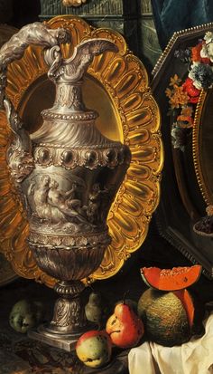 an ornate vase sitting on top of a table next to fruit