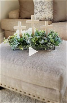 a couch with some plants on it and a cross sitting on top of the table