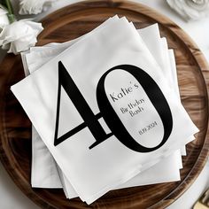 napkins with the number forty on them are sitting on a plate next to flowers