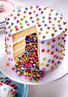 a white cake with sprinkles and a slice cut out