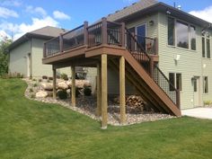 a house with a deck and stairs in the front yard