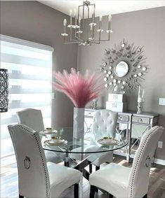 a dining room table with white chairs and a chandelier